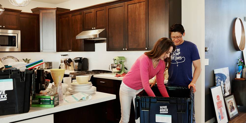 Renter reviewing a move-in checklist with boxes in a California apartment