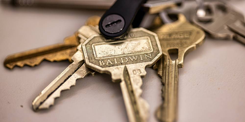 Renter handing apartment keys over moving boxes during California move-out