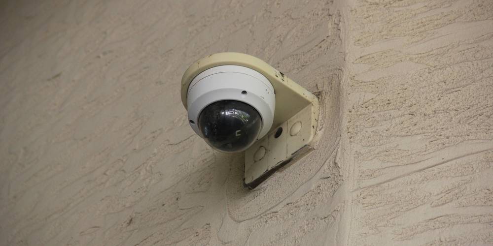 Tenant reading landlord entry notice and hallway security camera representing California tenant privacy rights