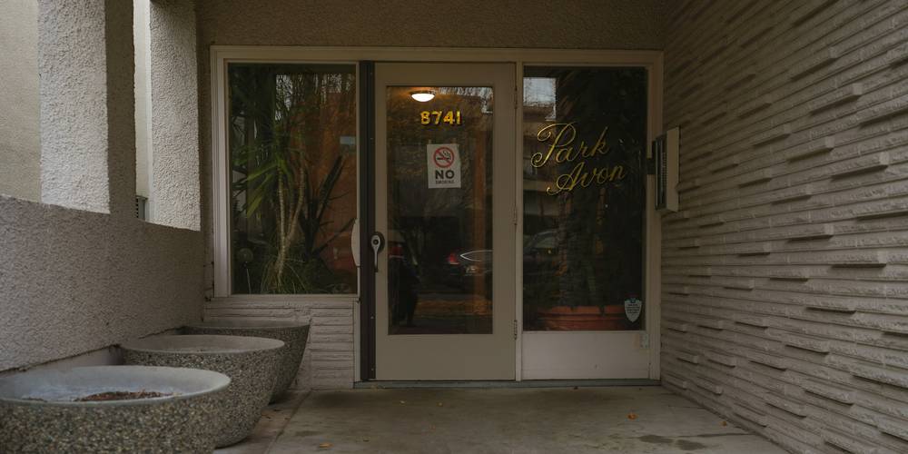 Tenant reviewing a landlord 24-hour entry notice at a California apartment door