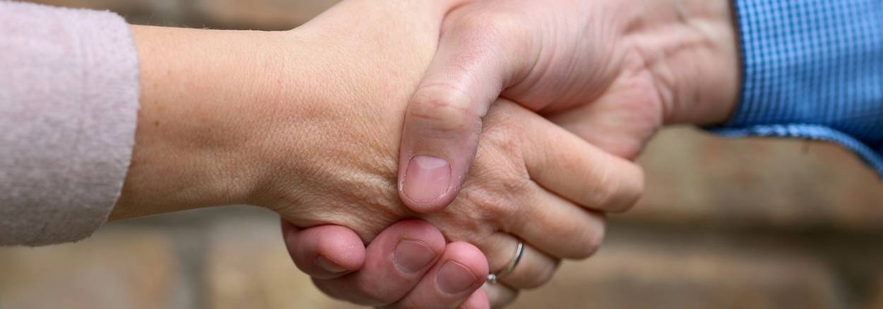 Tenant and landlord shake hands during California mediation session